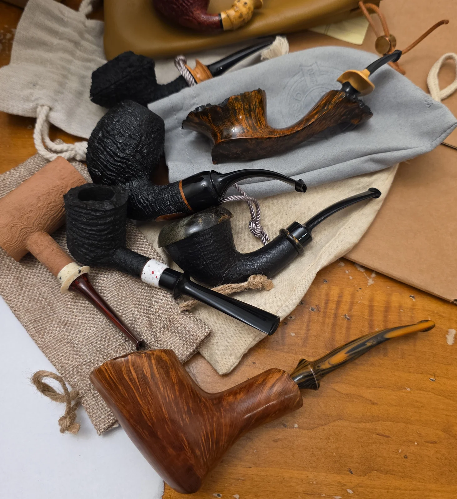Tobacco pipes and cloth pouches spread out on a wooden table